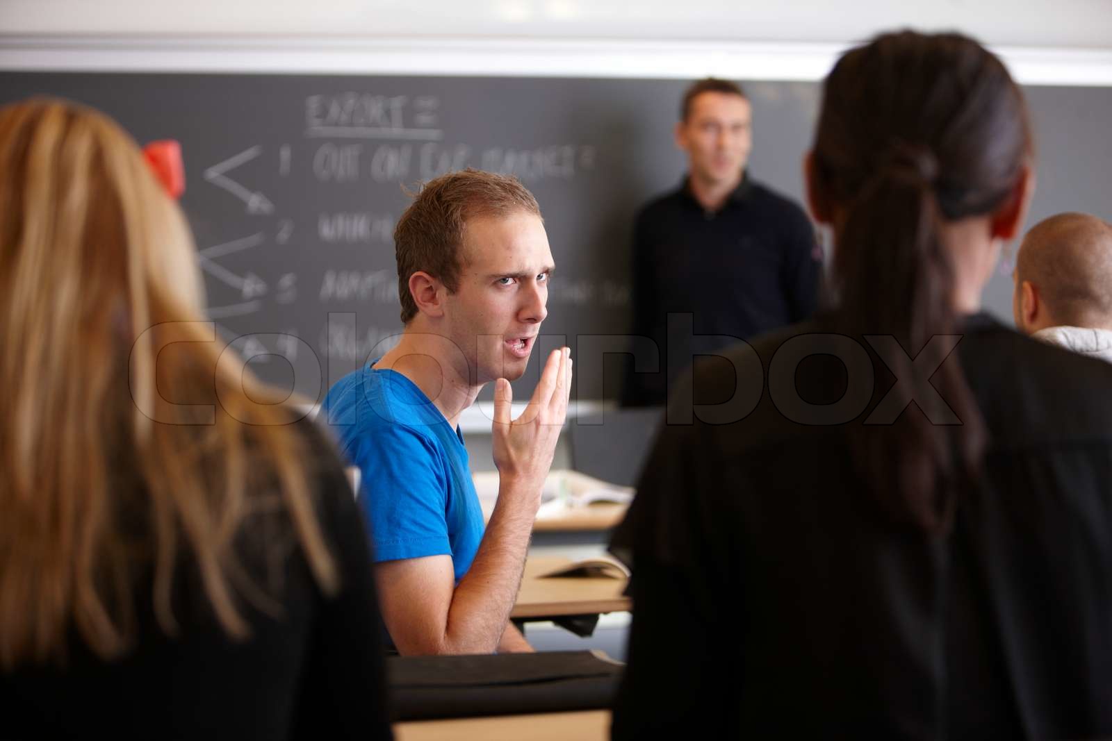 A school professor lecturing his students in a university auditorium ...