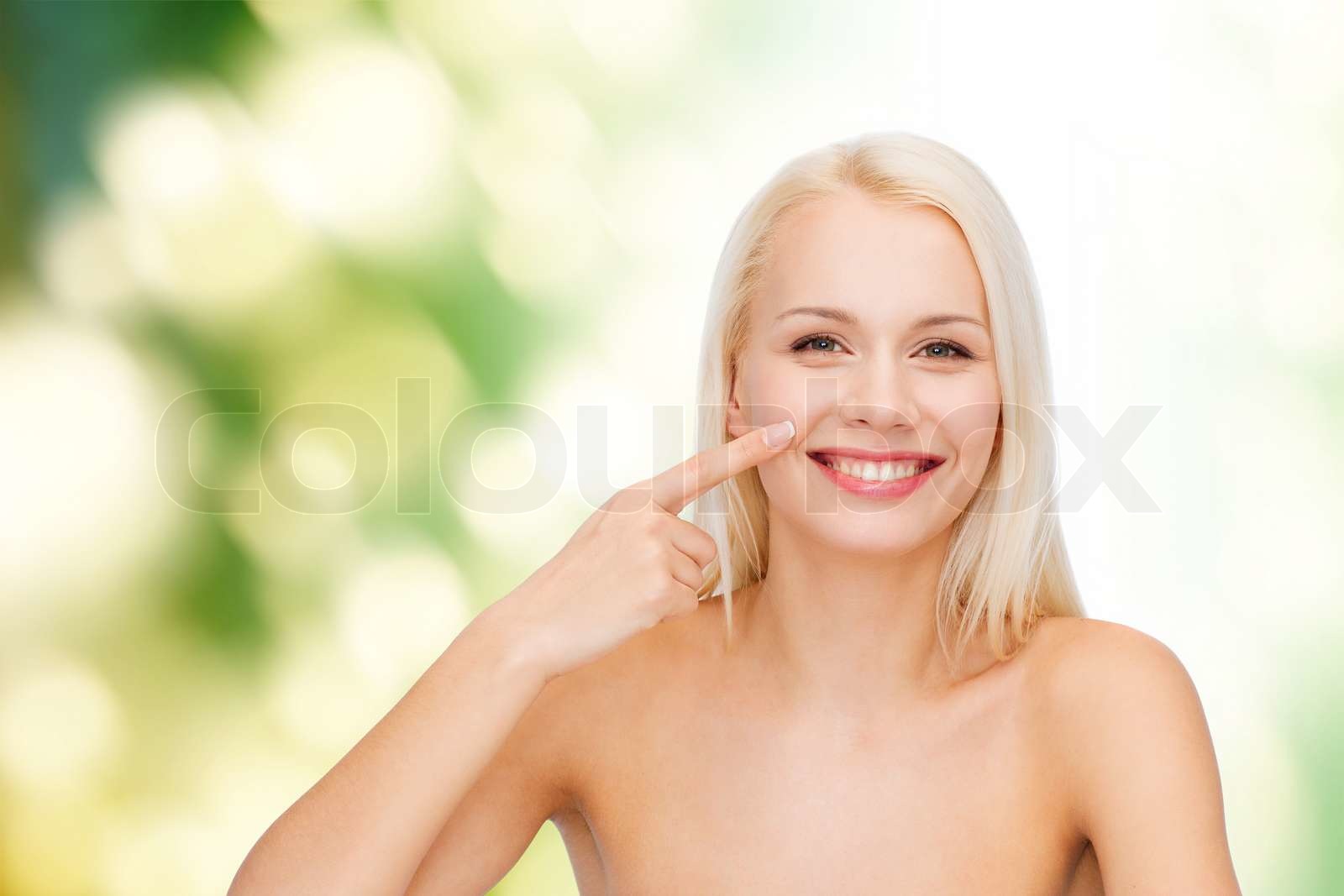 lächelnde junge Frau zeigte auf ihrer Nase | Stock Bild | Colourbox