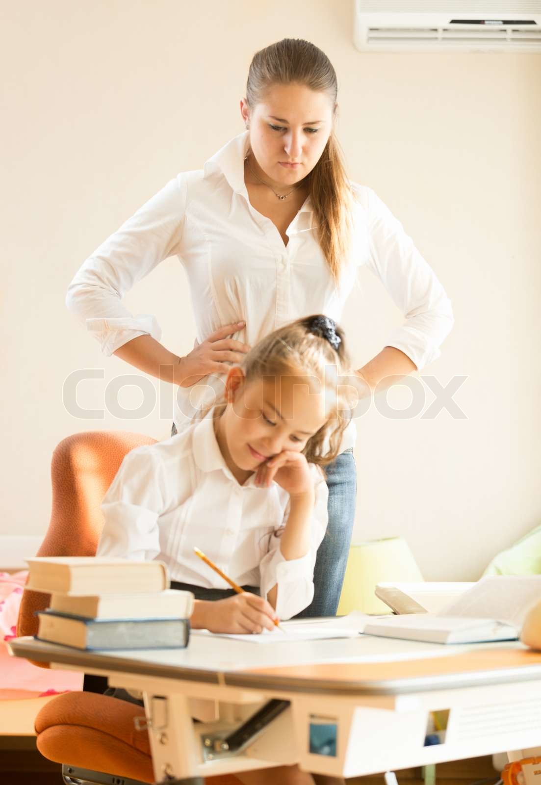mother watching at daughter doing homework | Stock image | Colourbox