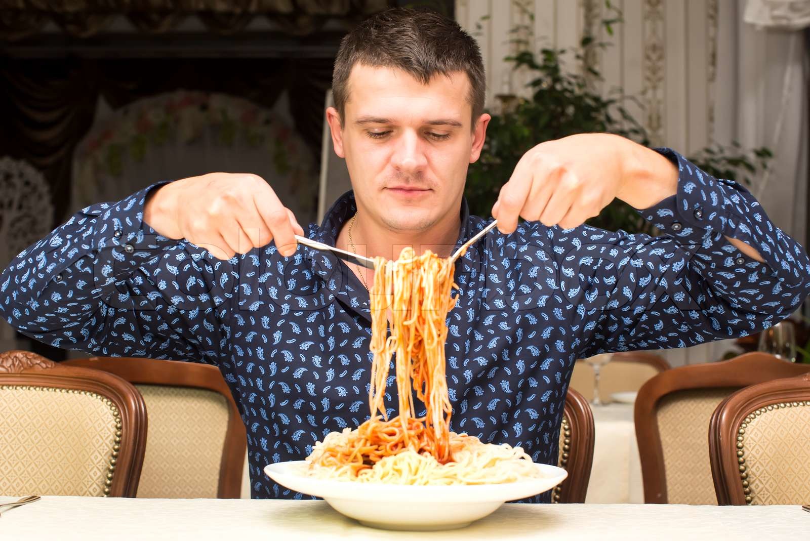 man eating a large portion of pasta in a restaurant Stock image