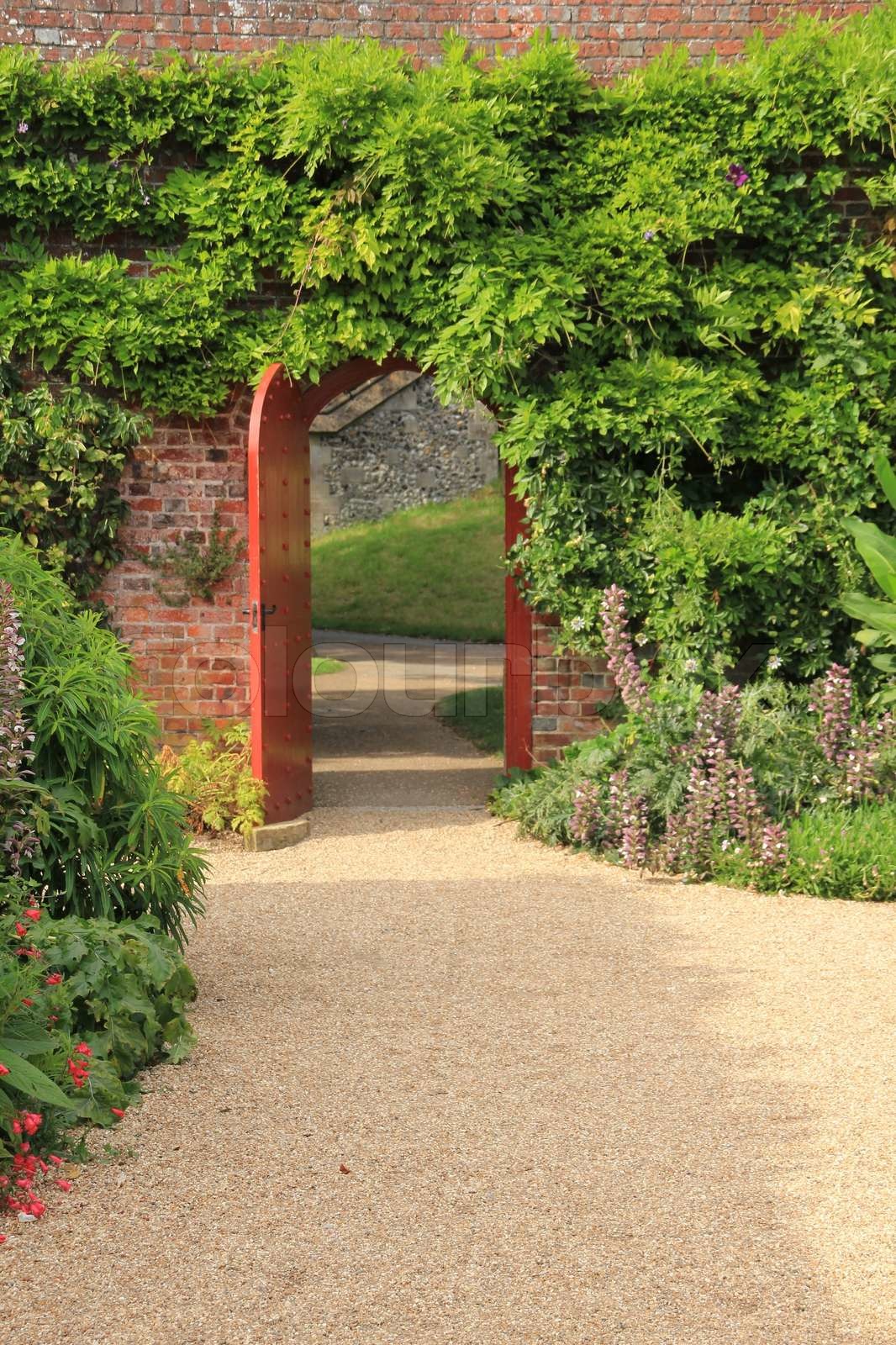 The Wall With The Green Ivy And An Open Door In The Summer In England