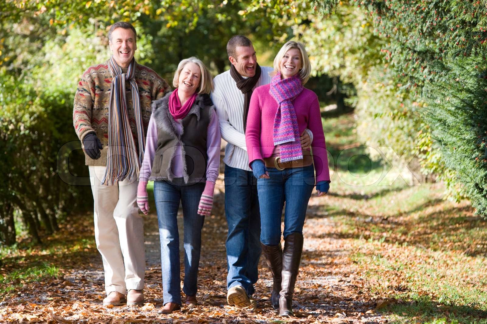 Eltern und erwachsenen Kindern zu Fuß durch Wald Herbst Stock Bild