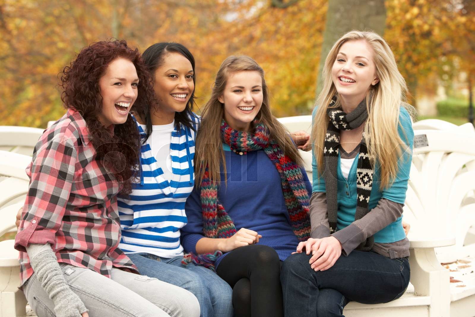Gruppe von vier Teenager sitzen auf Bank im Herbst Park | Stock Bild ...