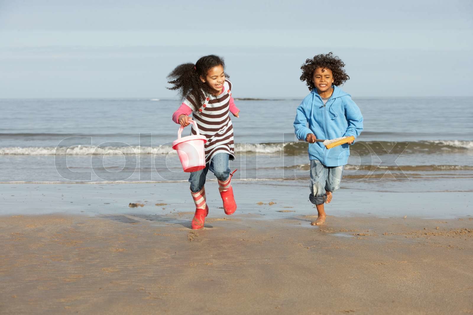 Brother and sister running on a beach | Stock image | Colourbox