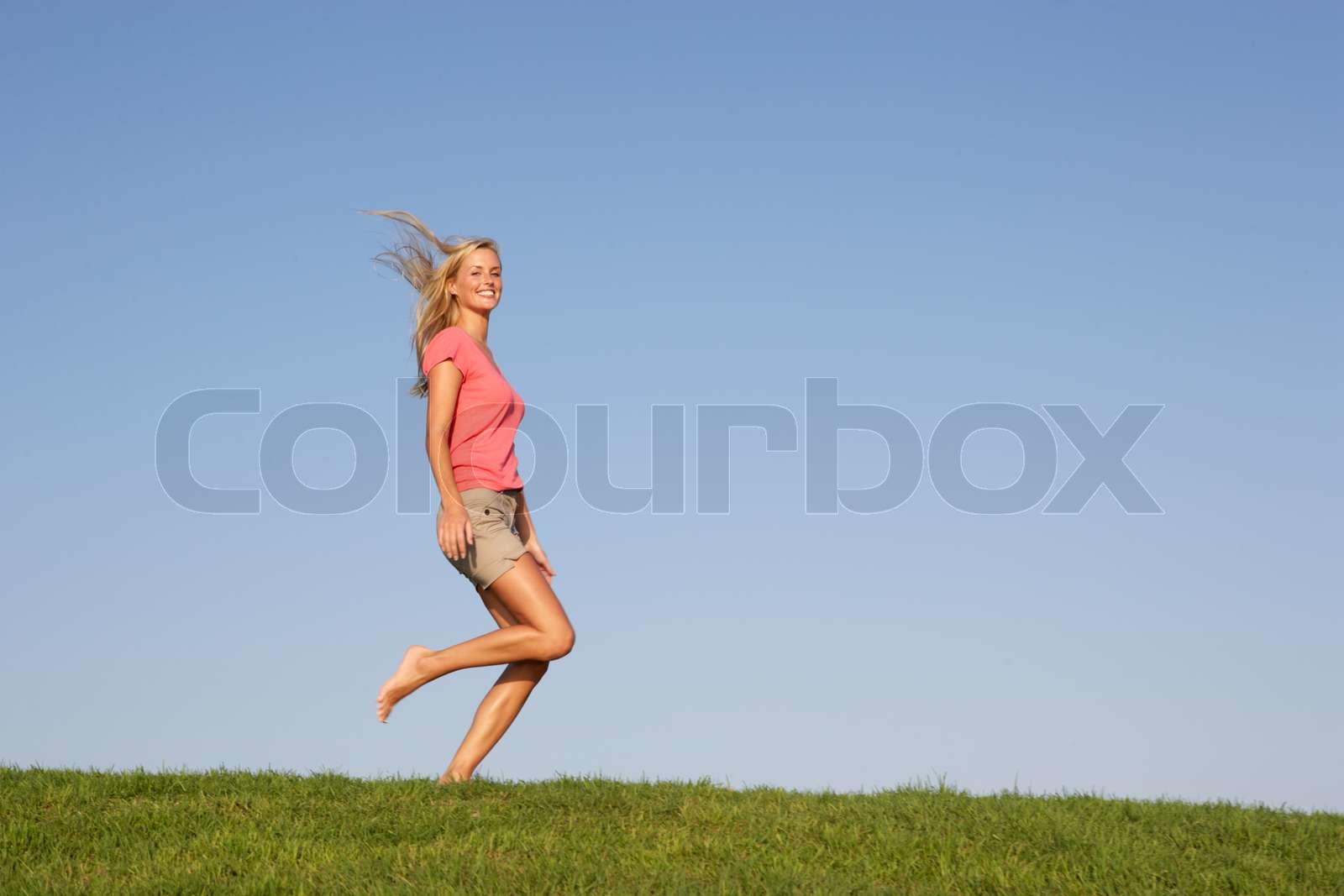 Young woman running through field Stock image Colourbox