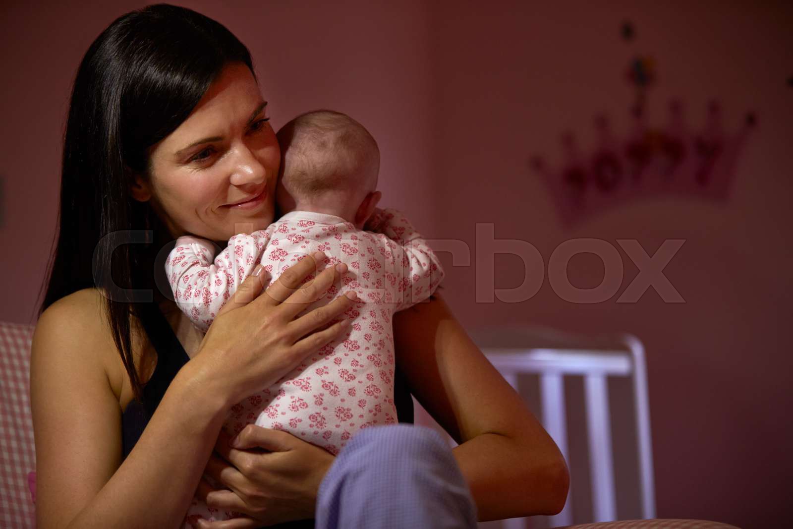 Mother At Home Cuddling Newborn Baby In Nursery Stock image Colourbox