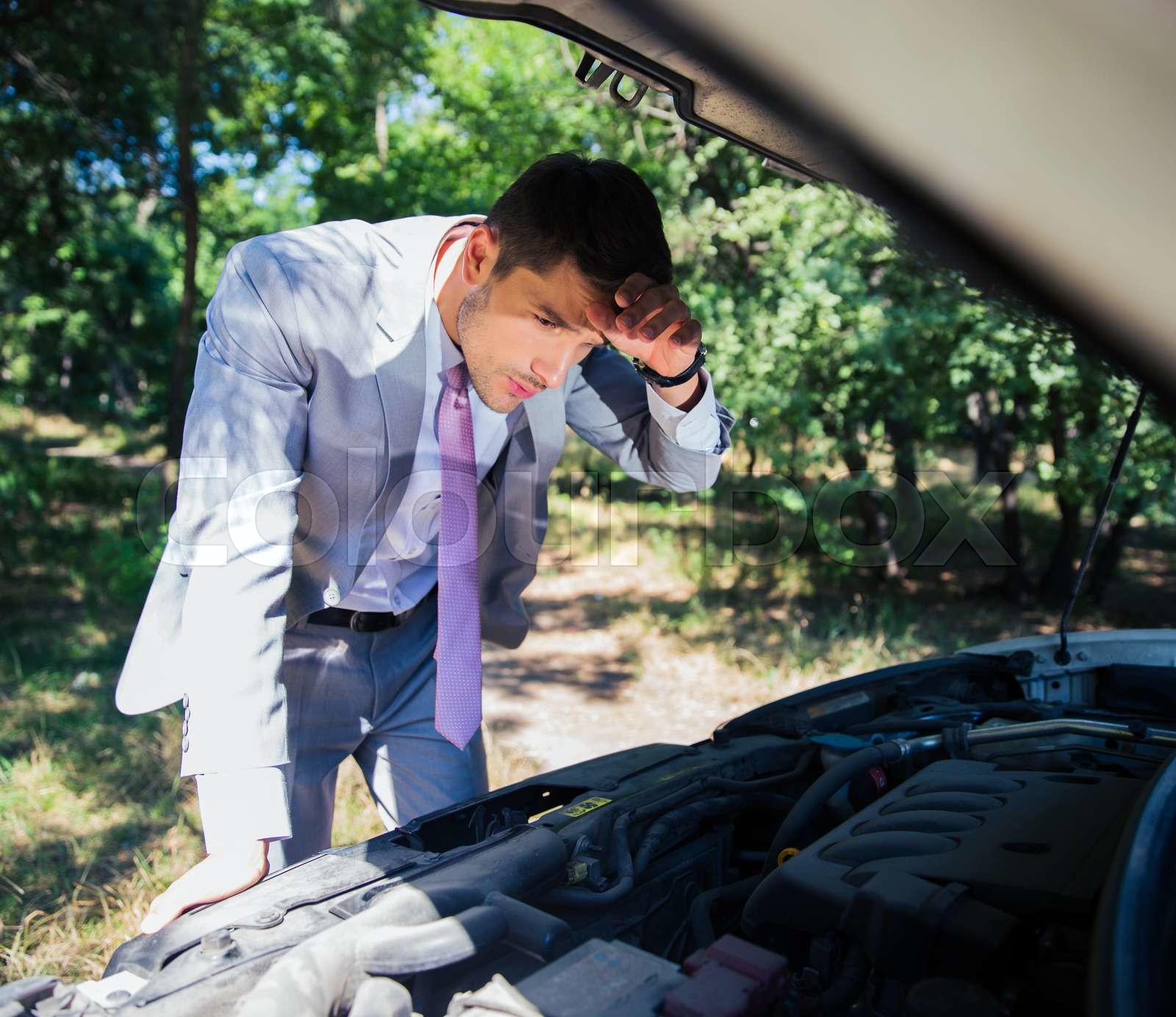 Man looking under the hood of car Stock image Colourbox
