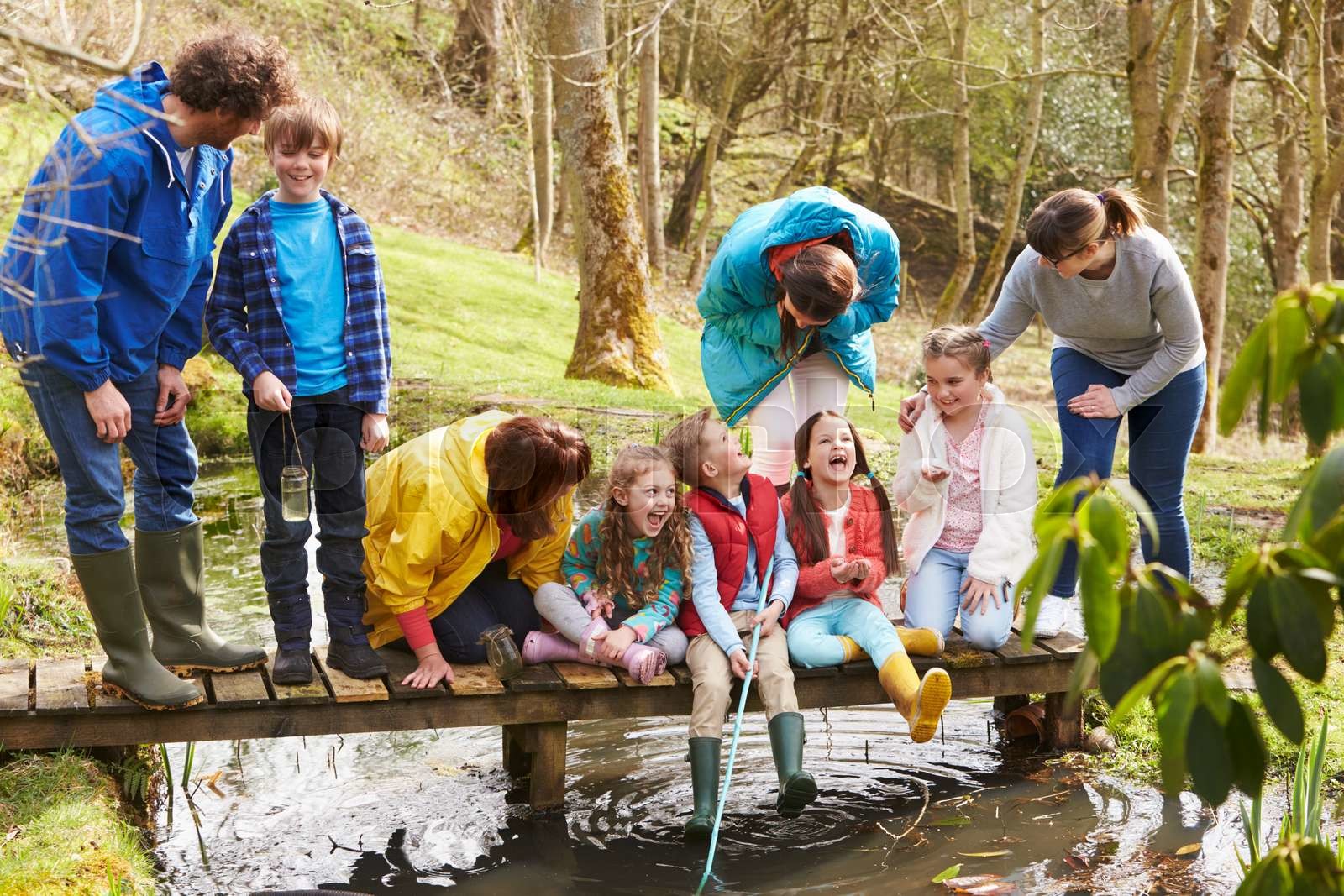 Adults With Children On Bridge At Outdoor Activity Centre Stock image