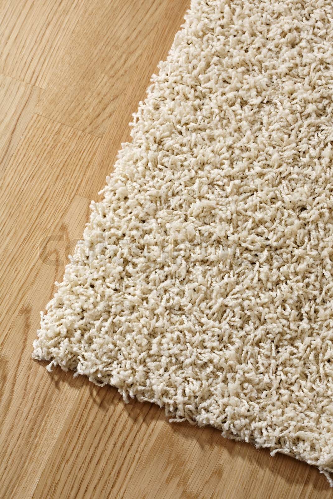 White synthetic rug on a oak parquet floor Stock image Colourbox