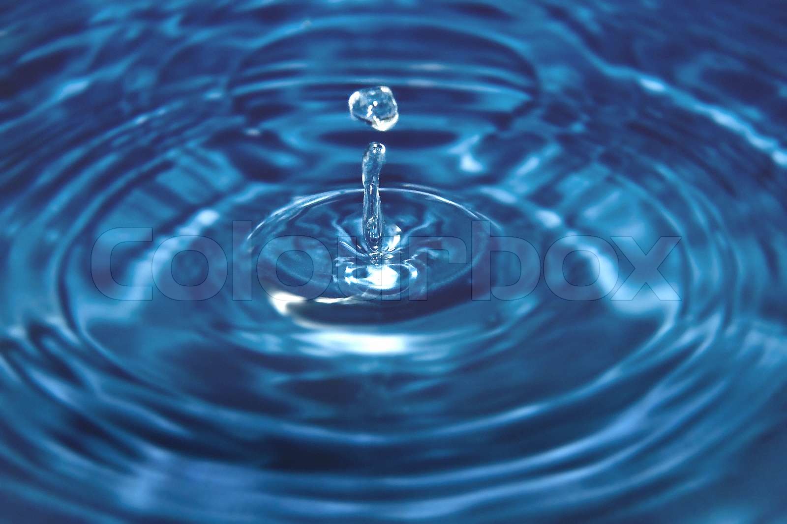 Ein Tropfen Wasser , wie es spritzt wieder in Blau und Weiß Duplex . Stock Bild Colourbox
