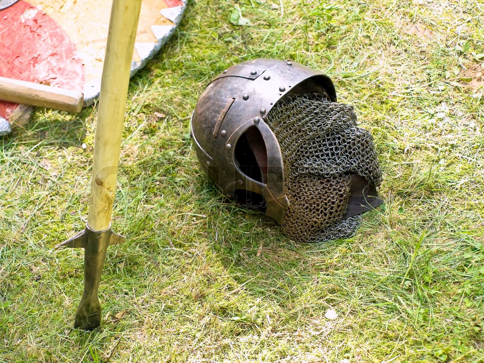 Knight metal helmet, pike and shield at the green grass Stock image