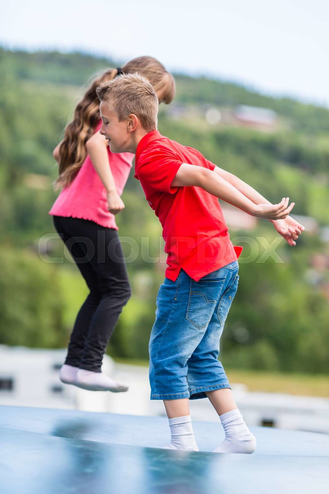 Children bouncing up and down on trampoline Stock image Colourbox