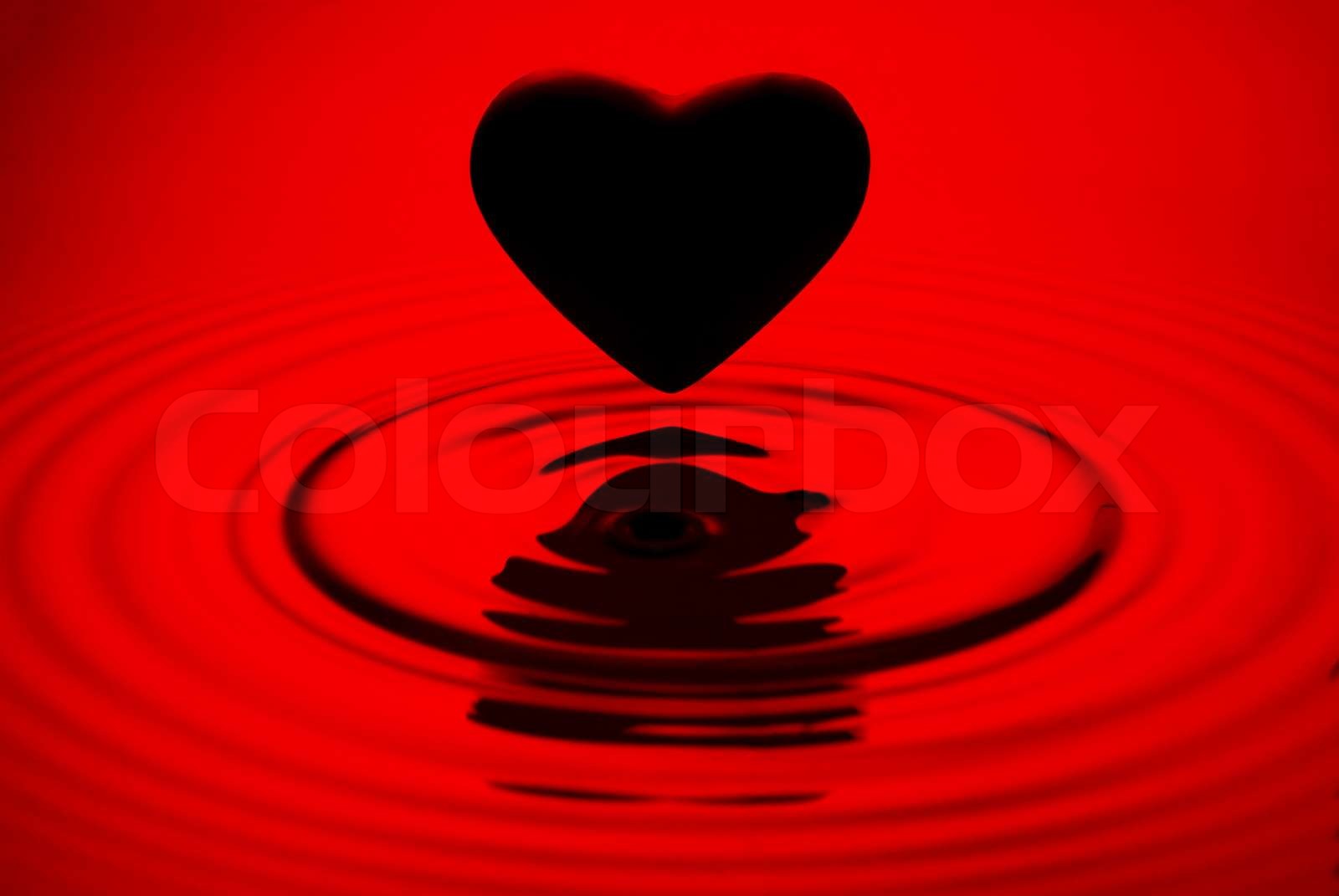 Schwarzes Herz Siluett über rot Wasserkräuselungen Hintergrund Stock