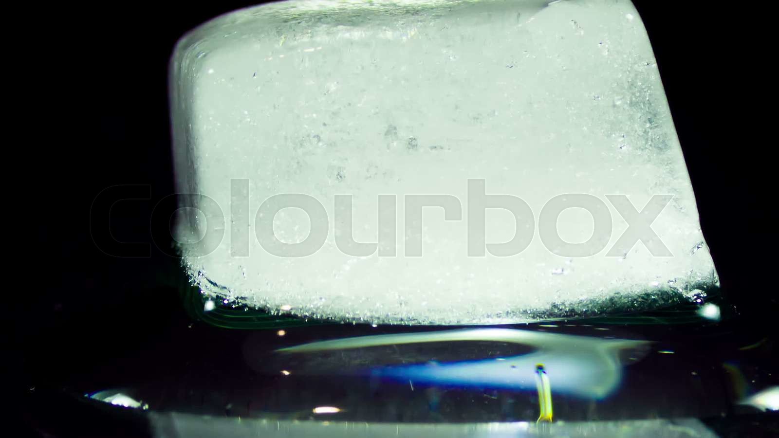 Ice Cube Melting and Moving on a Glass Surface Stock video Colourbox