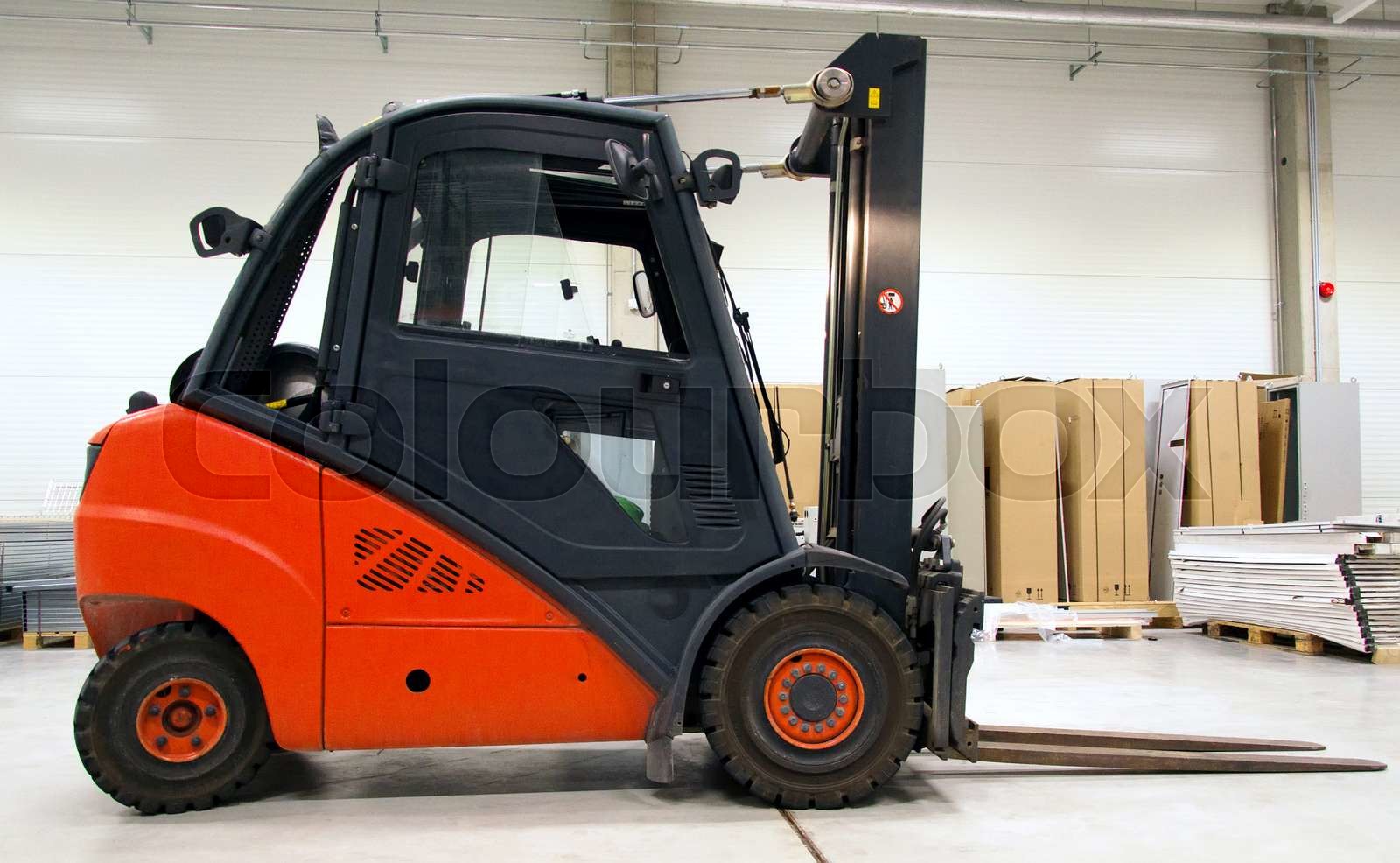 Orange forklift loader in the modern warehouse. | Stock image | Colourbox