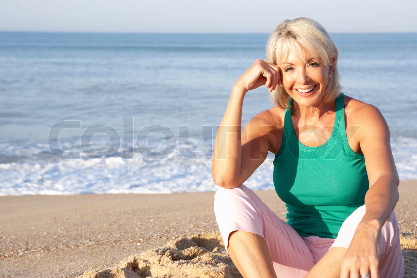 Senior woman sitting on beach relaxing | Stock image | Colourbox