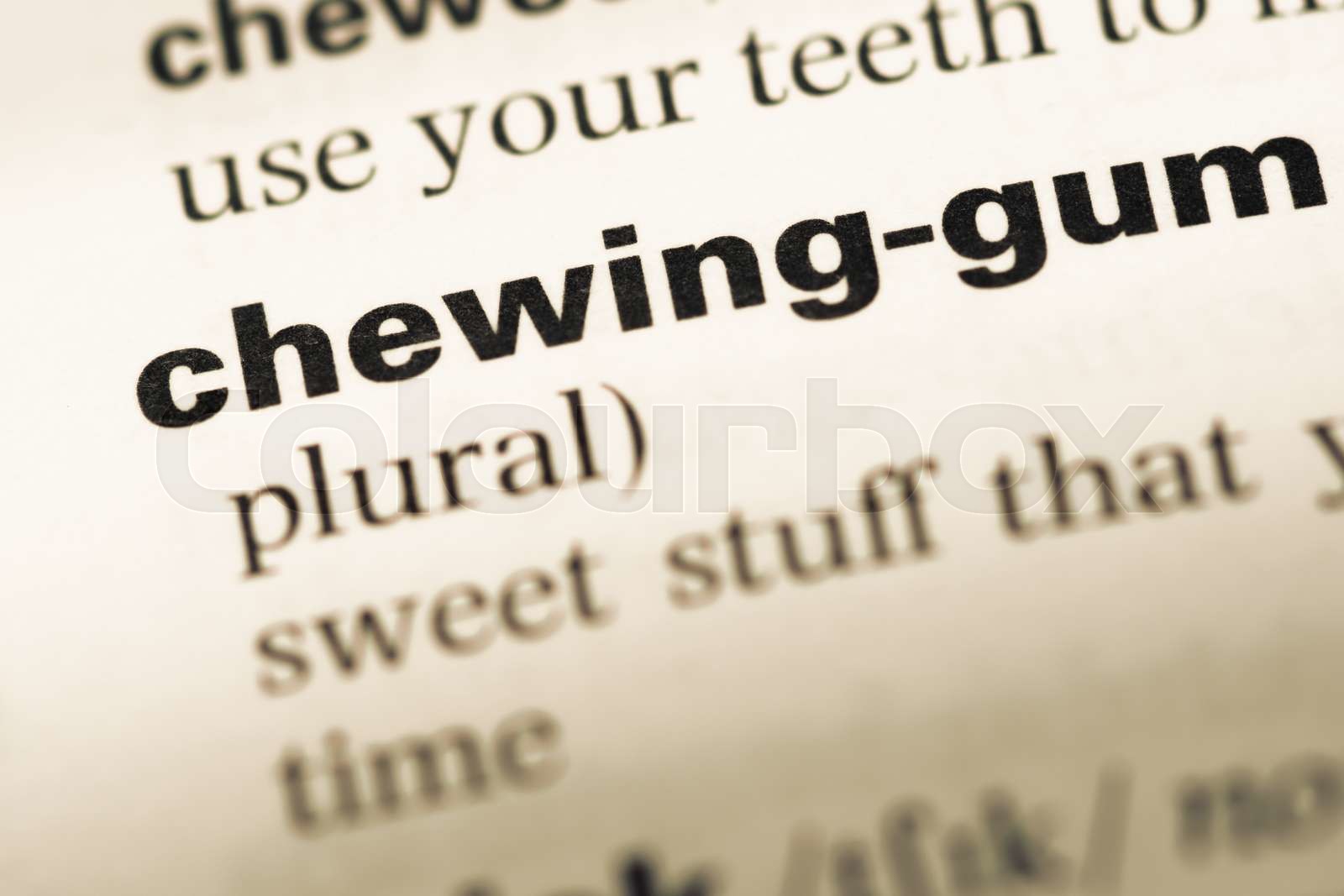 Close up of old English dictionary page with word chewing gum. Stock