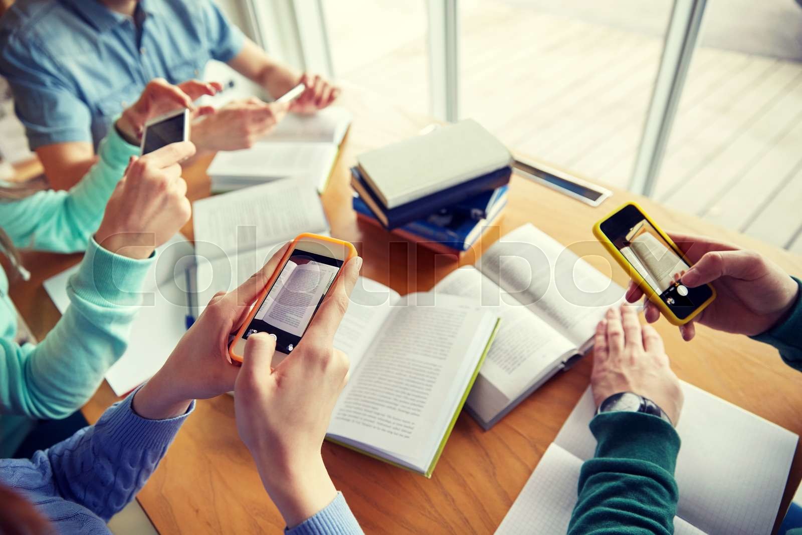 students with smartphones making cheat sheets | Stock image | Colourbox