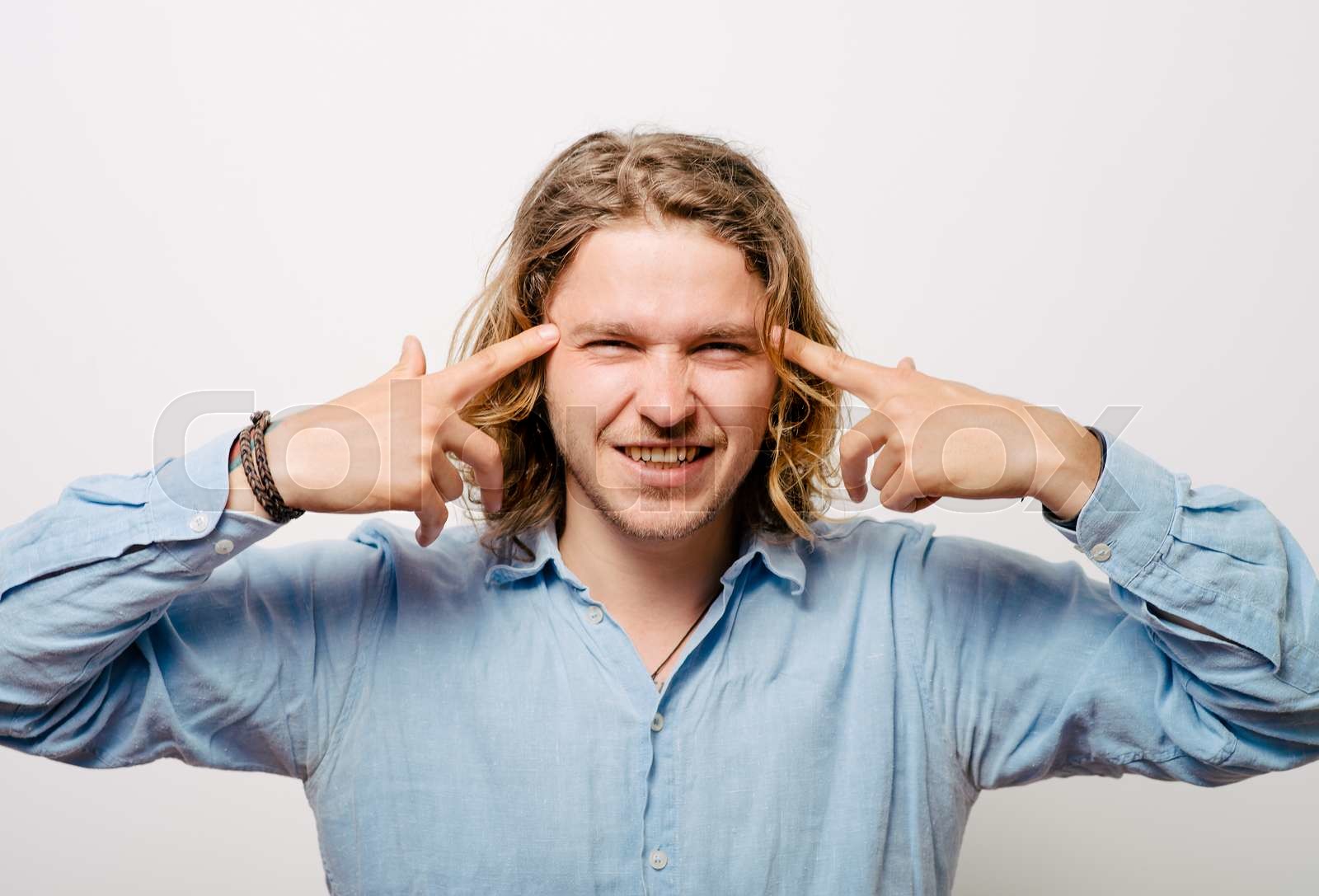 closeup-portrait-of-angry-man-gesturing-with-his-finger-against-his