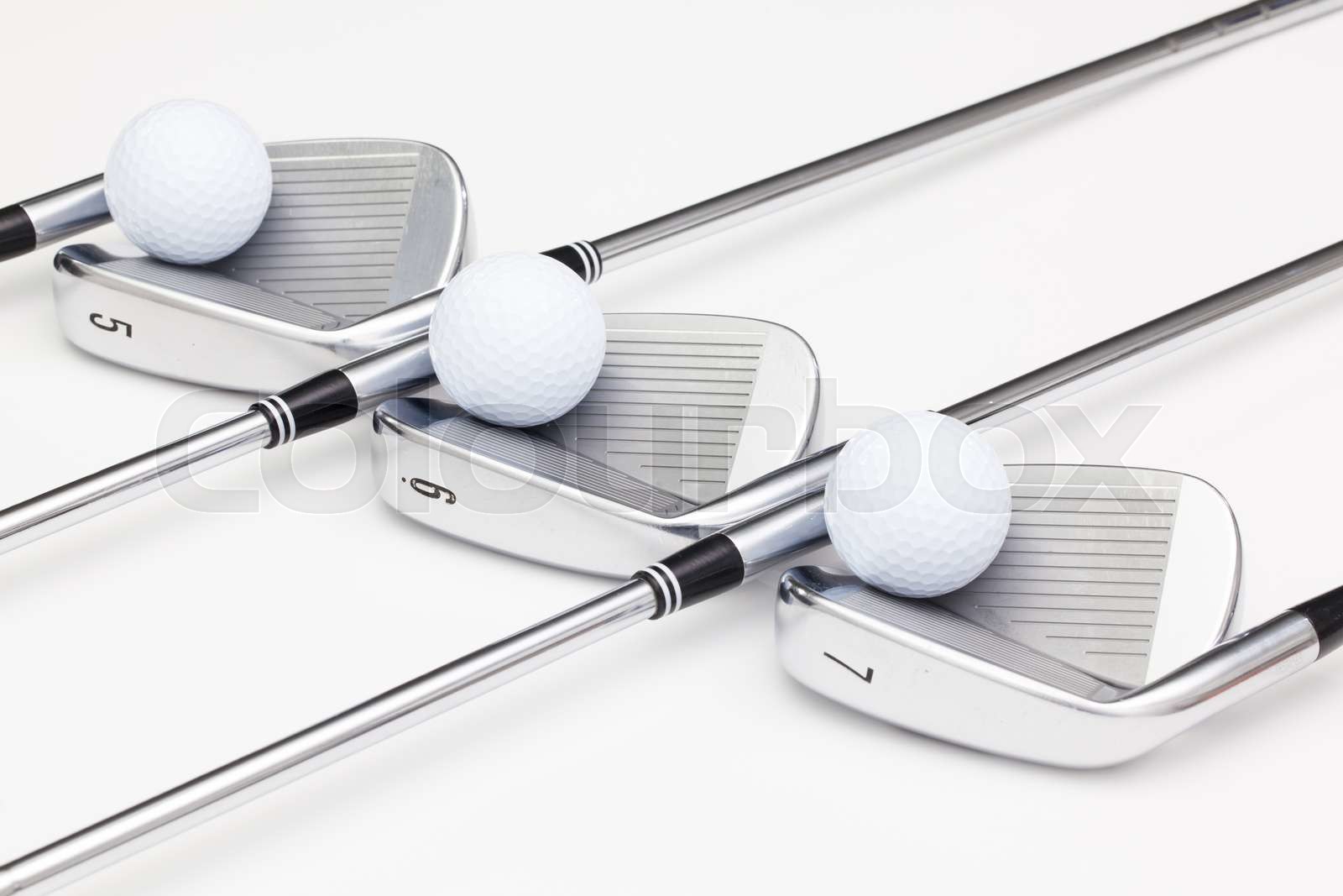 Titanium golf clubs on the white table Stock image Colourbox
