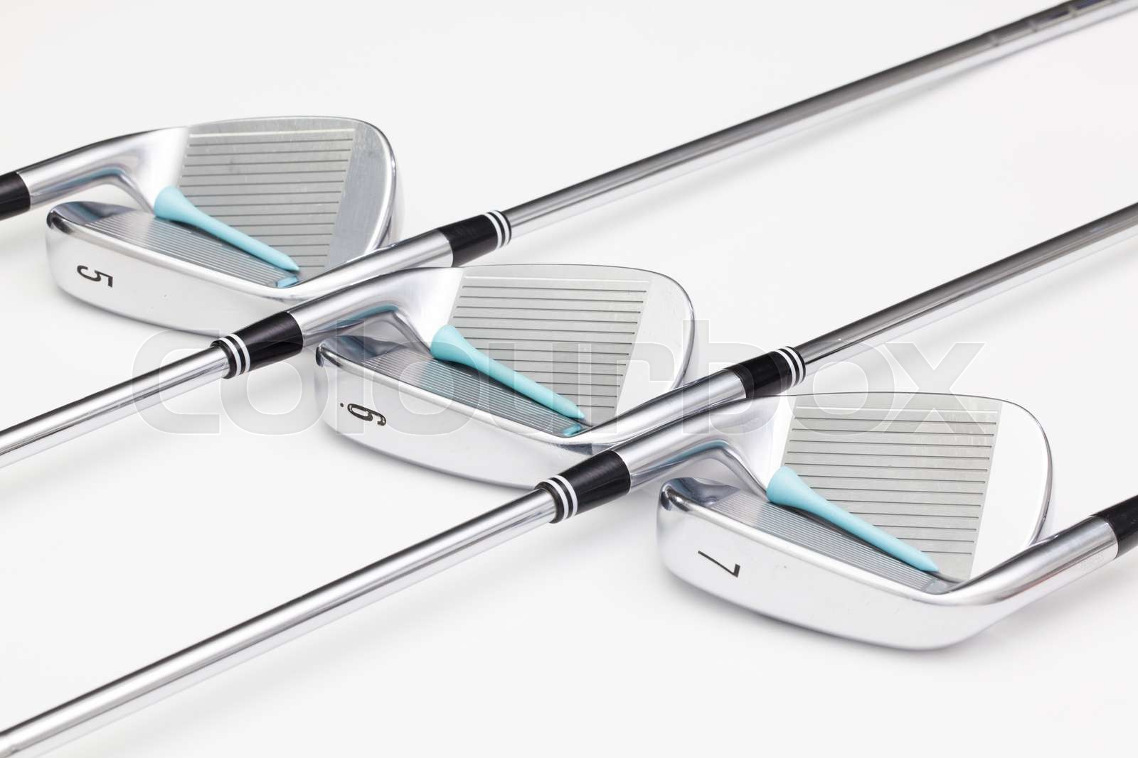 Titanium golf clubs on the white table Stock image Colourbox
