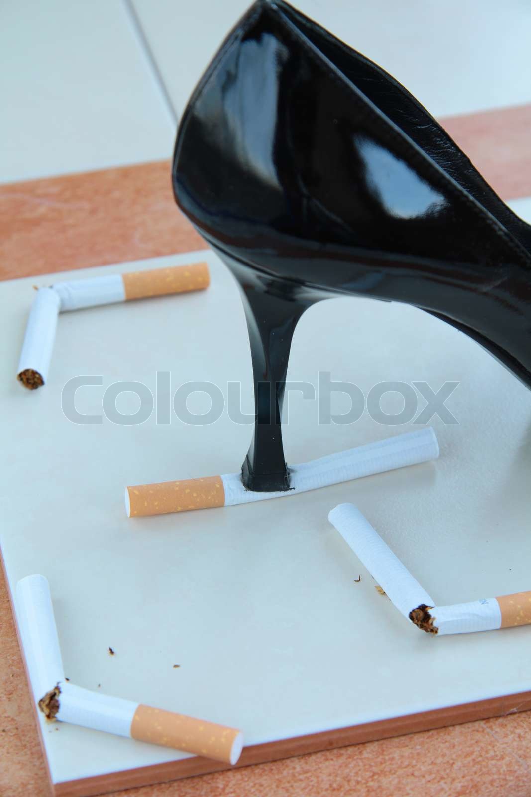 Women’s heel crushes cigarettes | Stock image | Colourbox