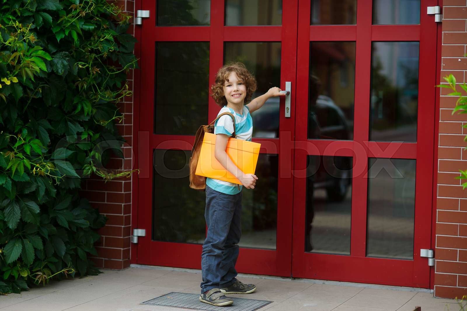 The pupil opens a school door. | Stock image | Colourbox