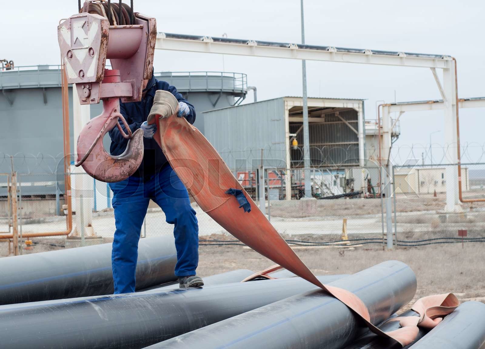 Work on unloading of pipes for construction. | Stock image | Colourbox
