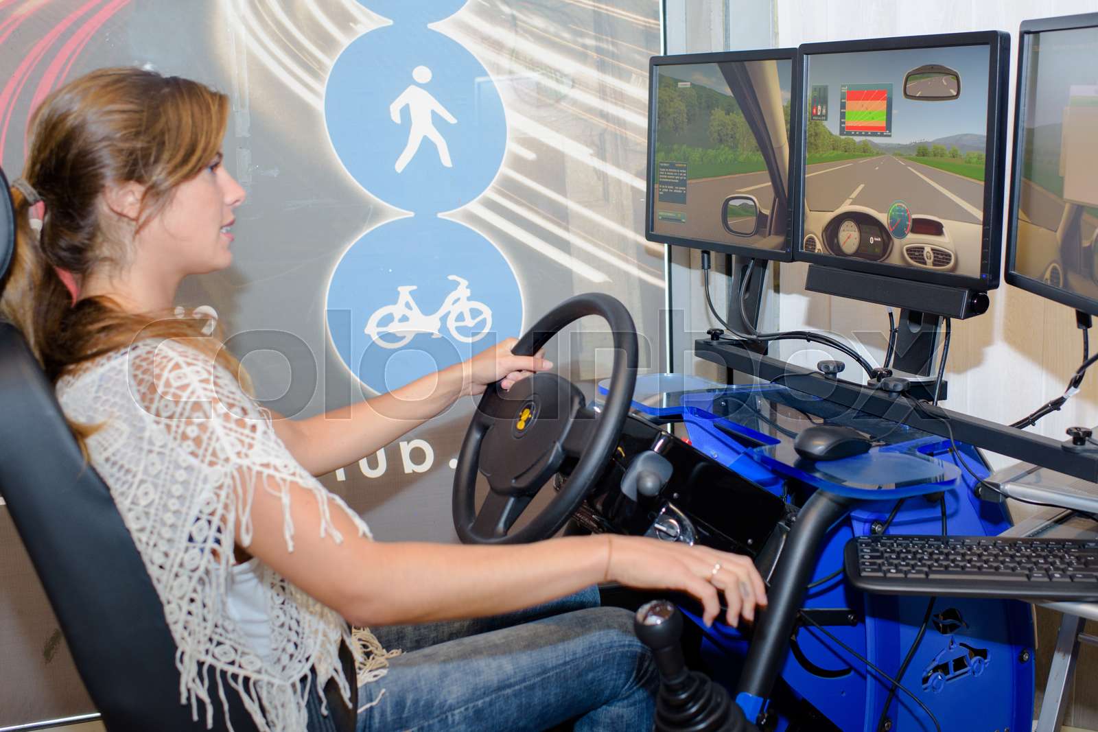 Lady using driving simulator | Stock image | Colourbox