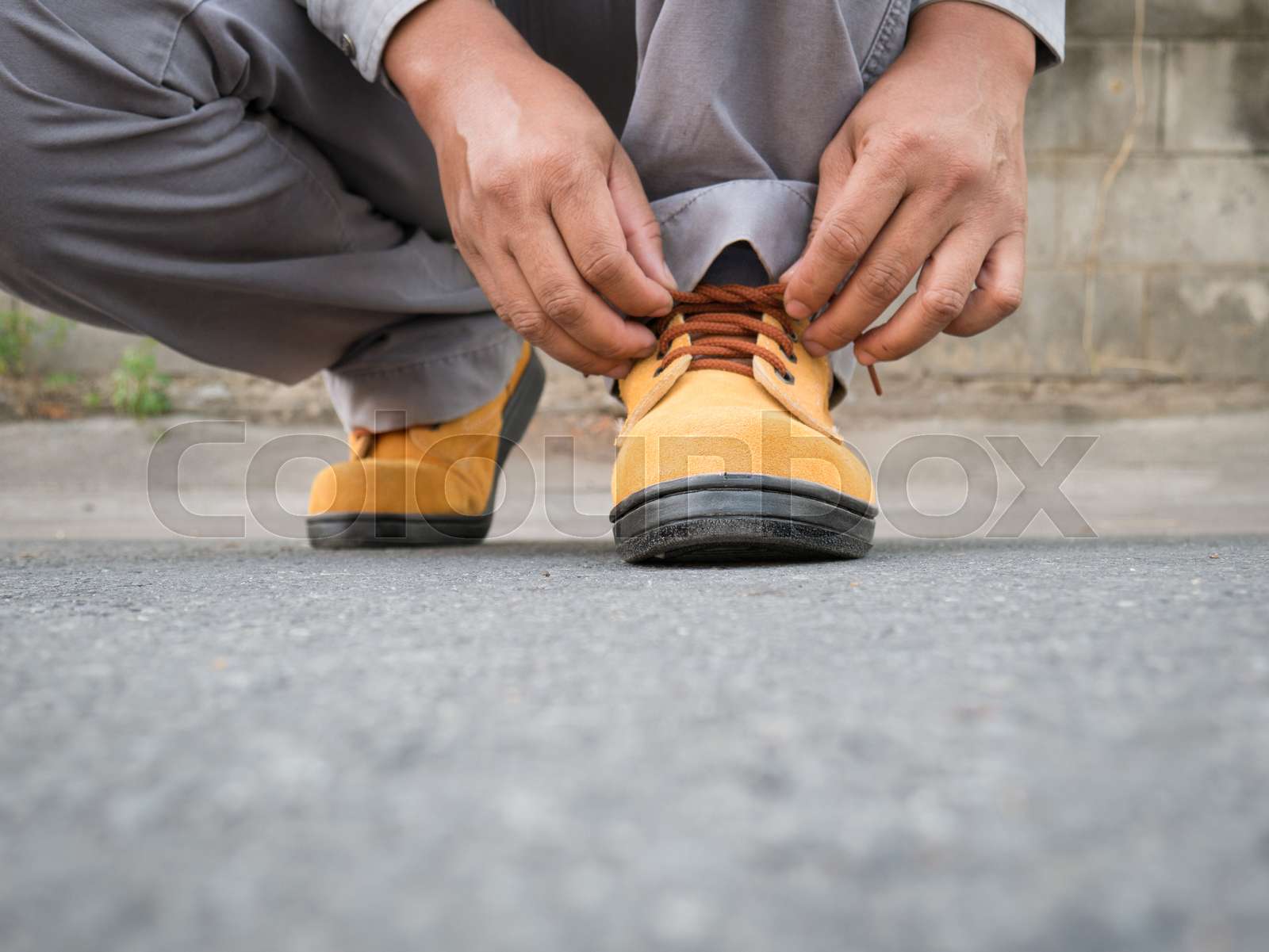 Man wears safety shoes on street Stock image Colourbox
