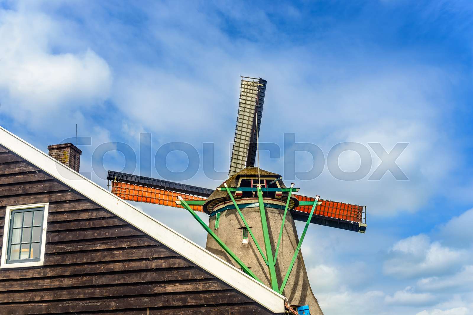 Tall windmill behind single story farmhouse | Stock image | Colourbox