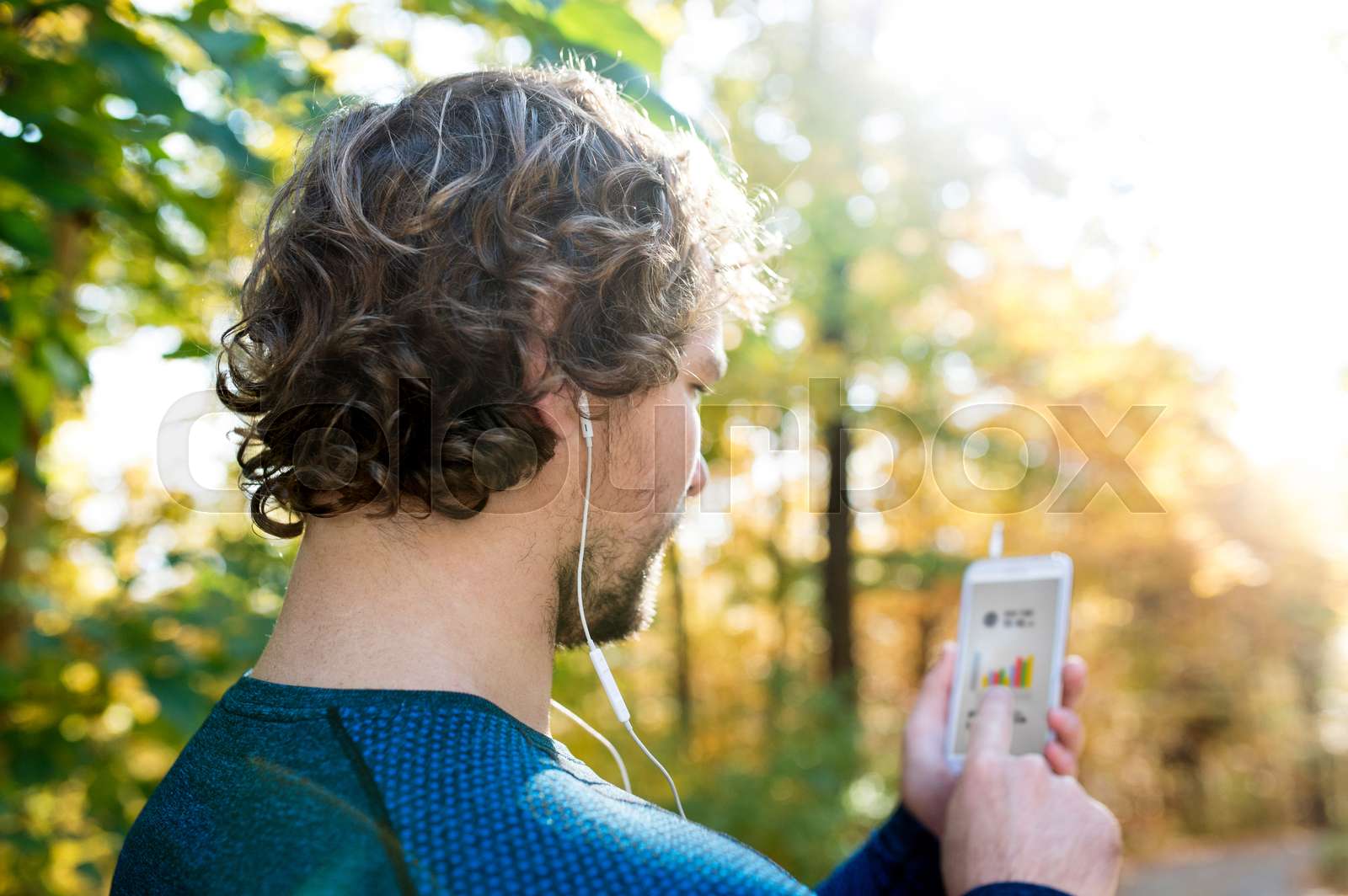 Man running with smart phones and earphones | Stock image | Colourbox