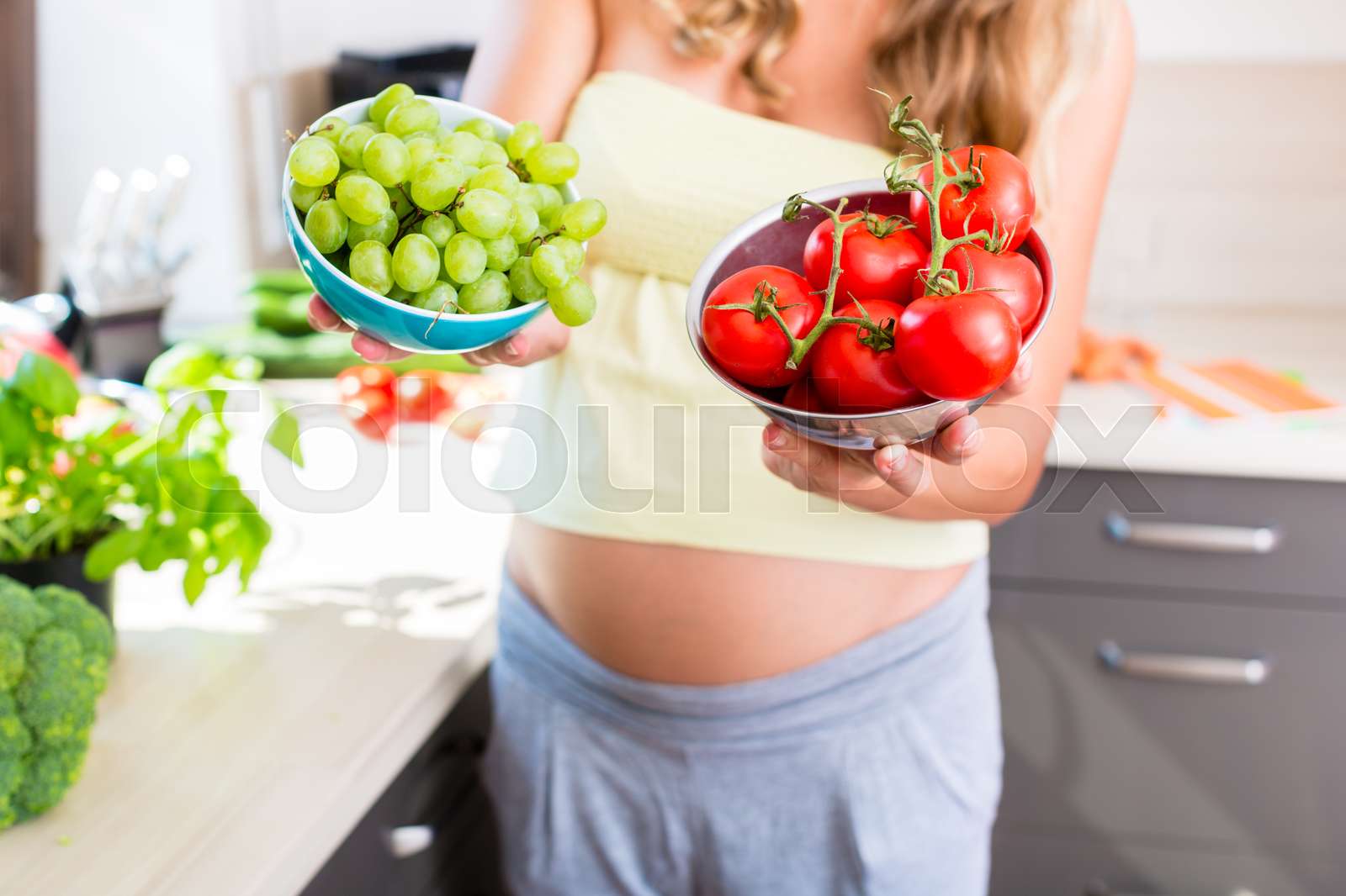 Pregnant woman showing fruit and vegetables Stock image Colourbox