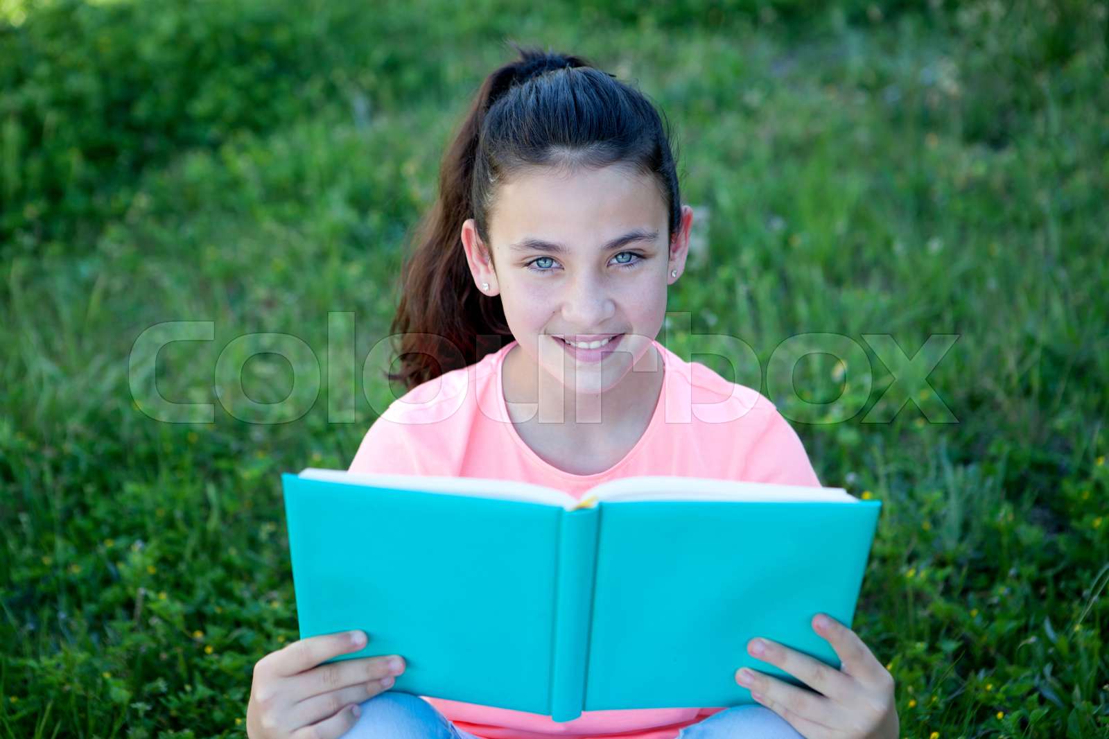 Beautiful preteen girl with blue eyes reading a book | Stock image ...