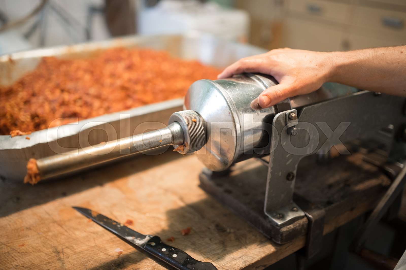 Man making sausages the traditional way using sausage filler. Stock