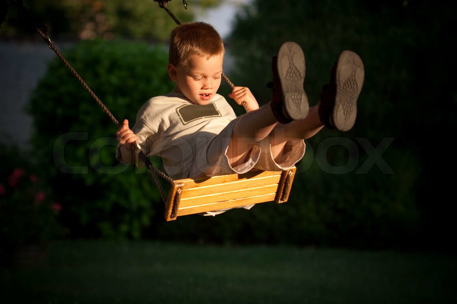 A young child playing on a swing | Stock image | Colourbox