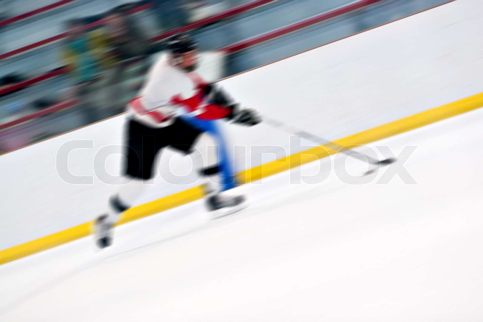 Abstract motion blur of a hockey player handling the puck as he speeds