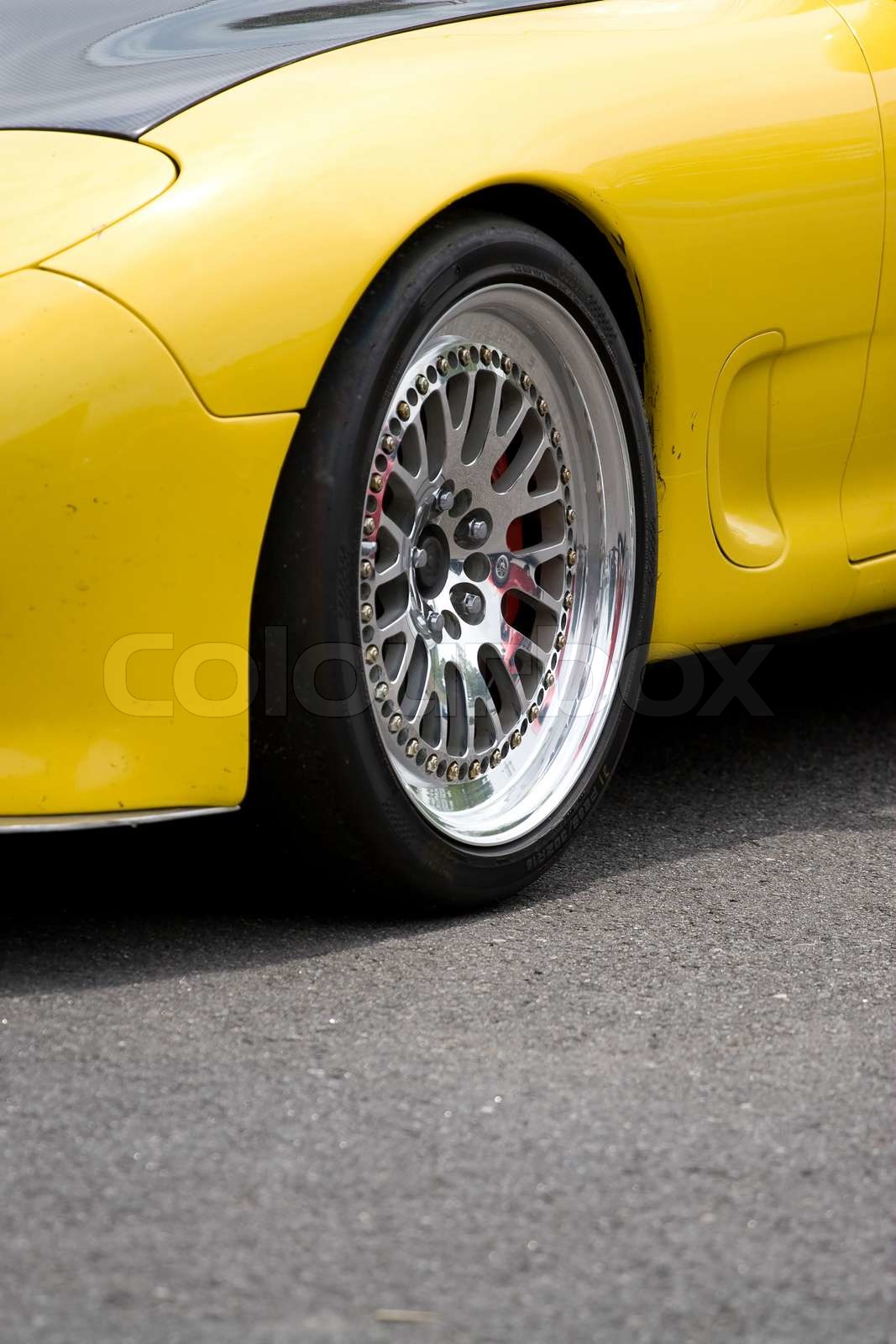 A closeup of the custom rims on a modern sports car with plenty of ...