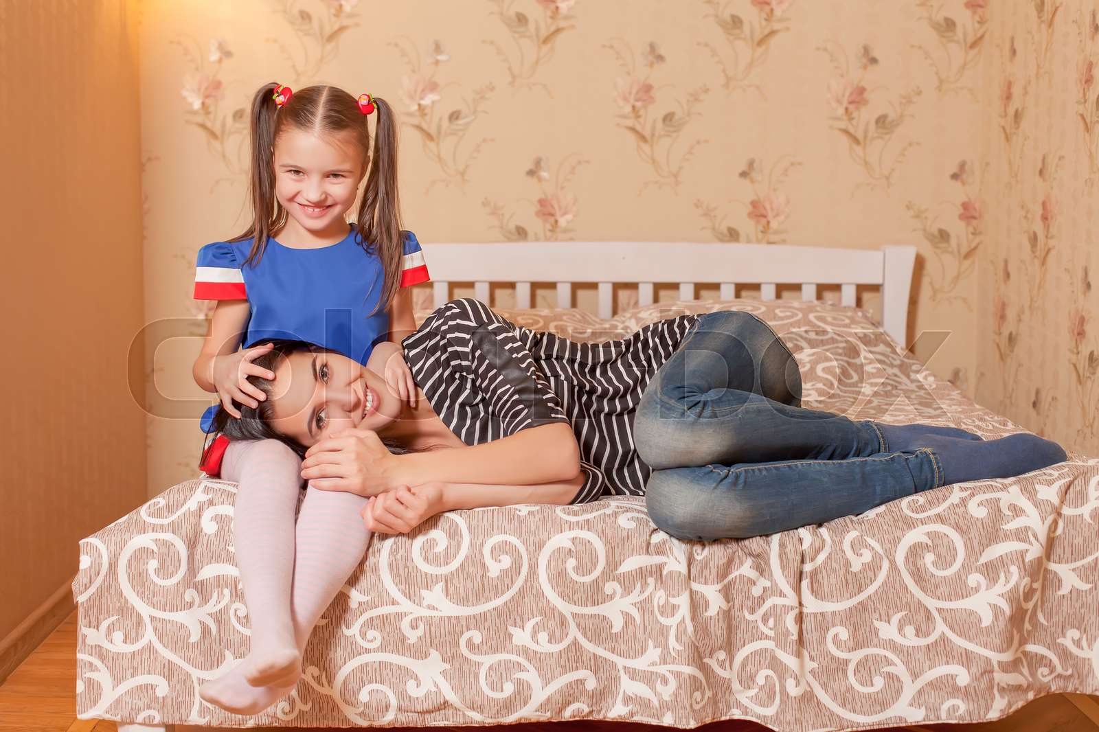 Mother lies on a laps of her daughter. | Stock image | Colourbox