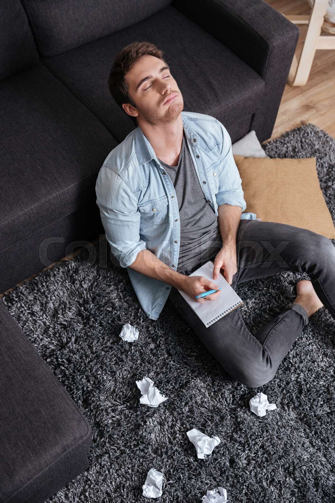 Man sitting on a carpet with eyes closed Stock image Colourbox