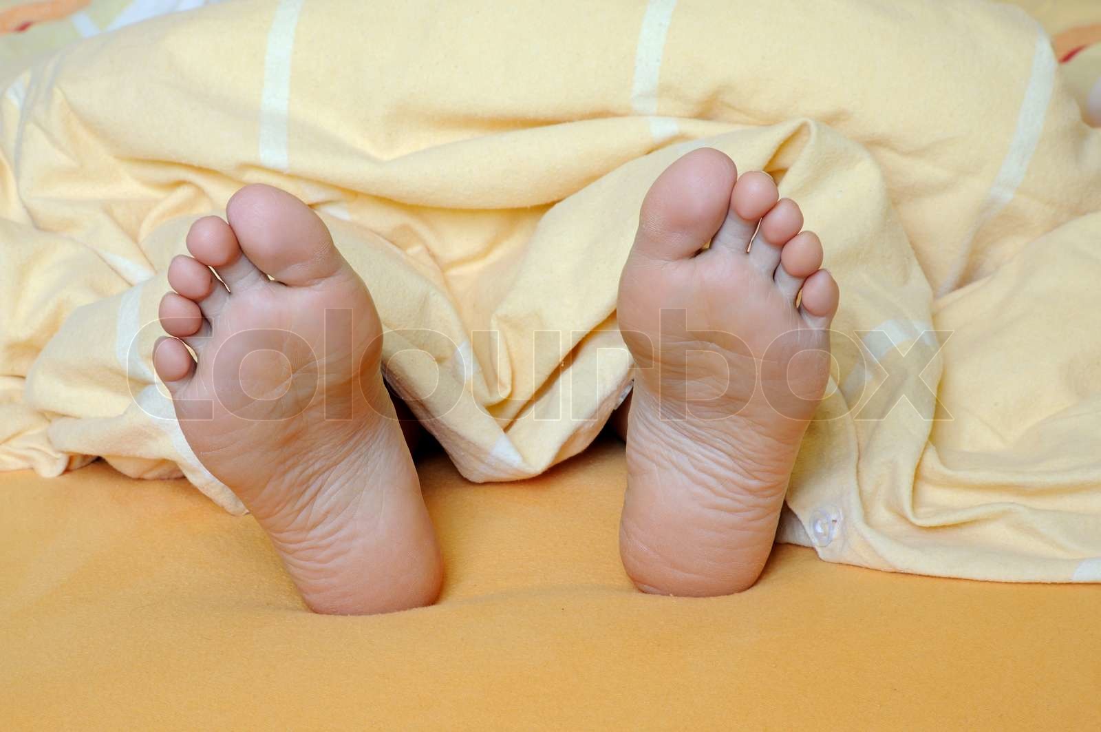 Weibliche Füße im Bett Stock Bild Colourbox