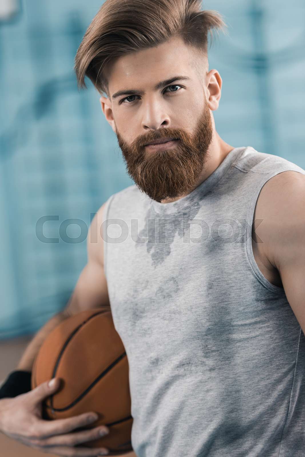 young basketball player holding ball and looking at camera Stock