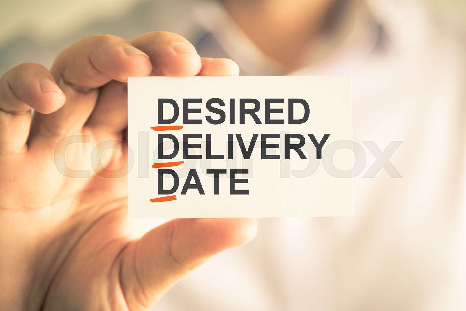 Businessman Holding Card With DDD DESIRED DELIVERY DATE Acronym Text 