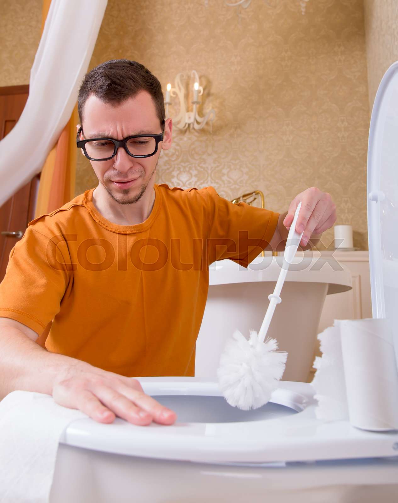 Man in glasses cleans the toilet bowl by brush Stock image Colourbox