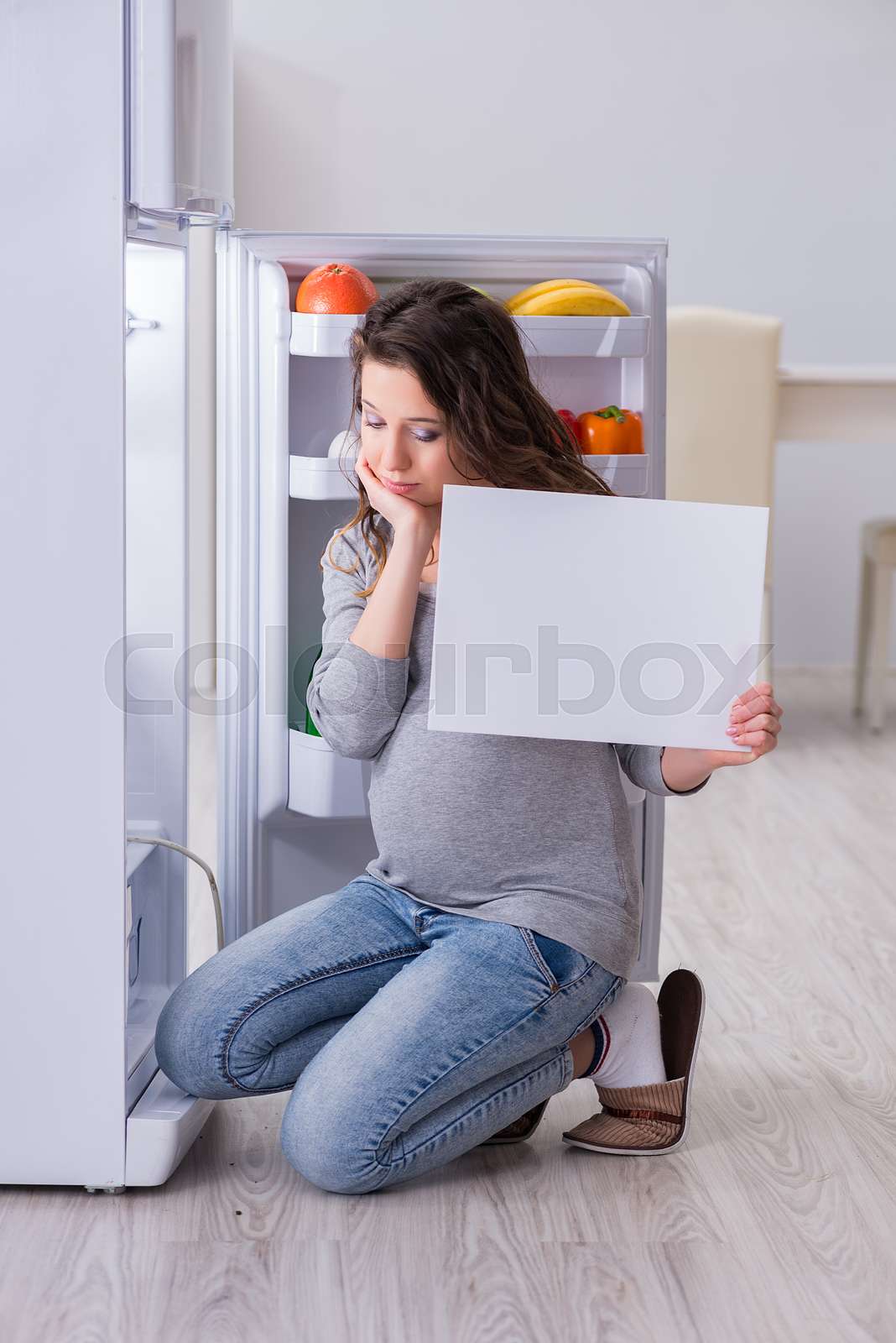 Pregnant woman near fridge with blank message Stock image Colourbox