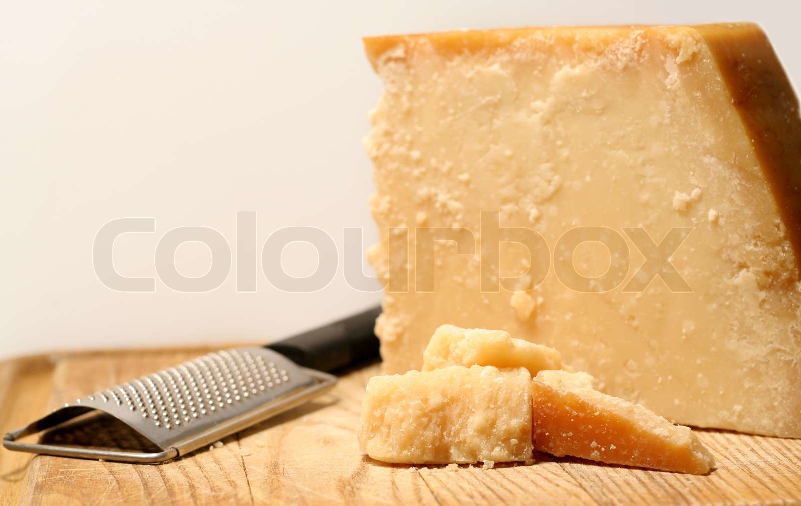 Block of parmesan cheese with grater Stock image Colourbox