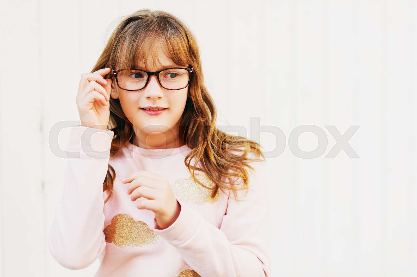 Outdoor Portrait Of A Cute Little 9 Year Old Girl Wearing Soft Pink