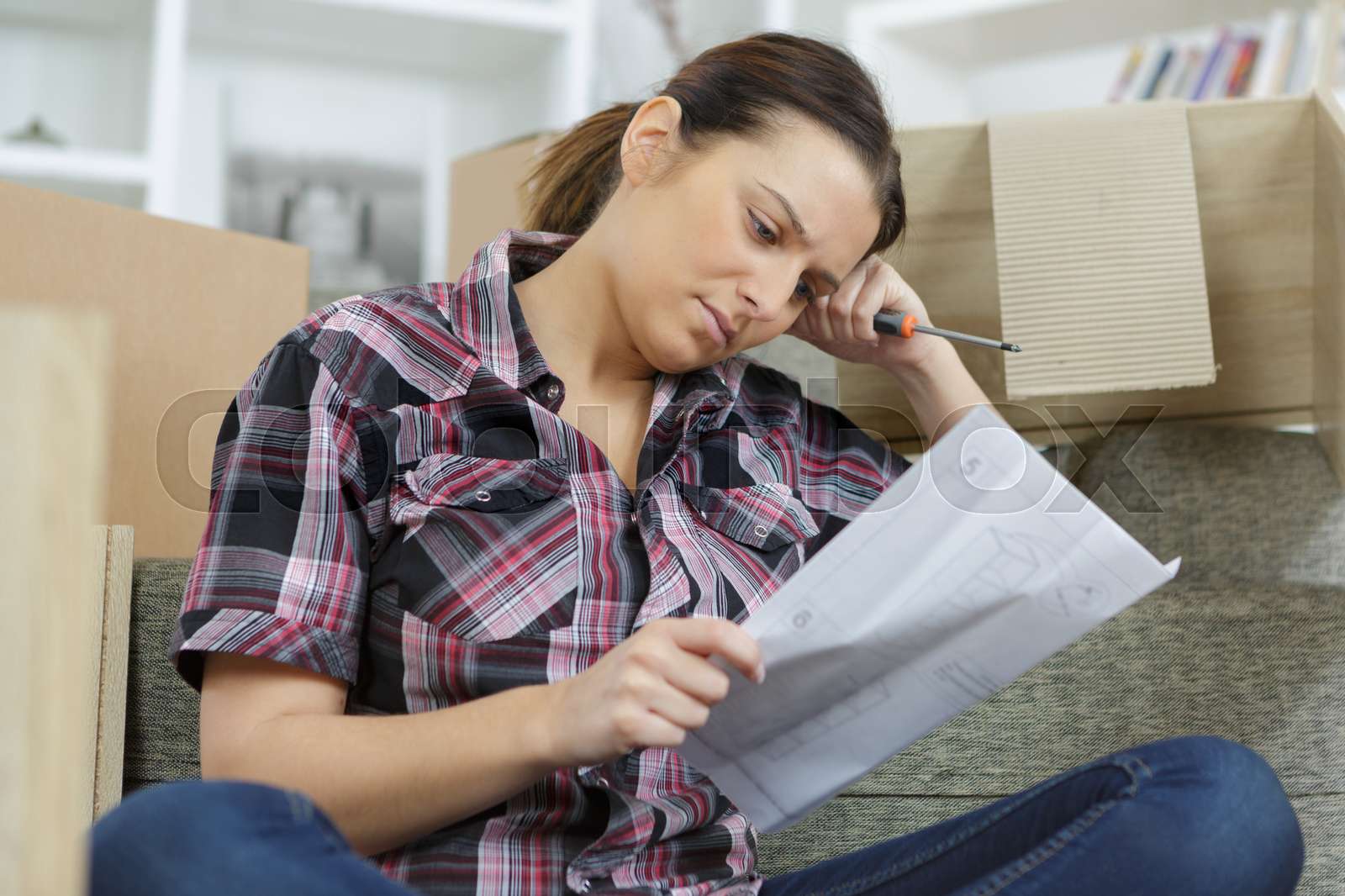 frustrated woman putting together self assembly furniture | Stock image ...