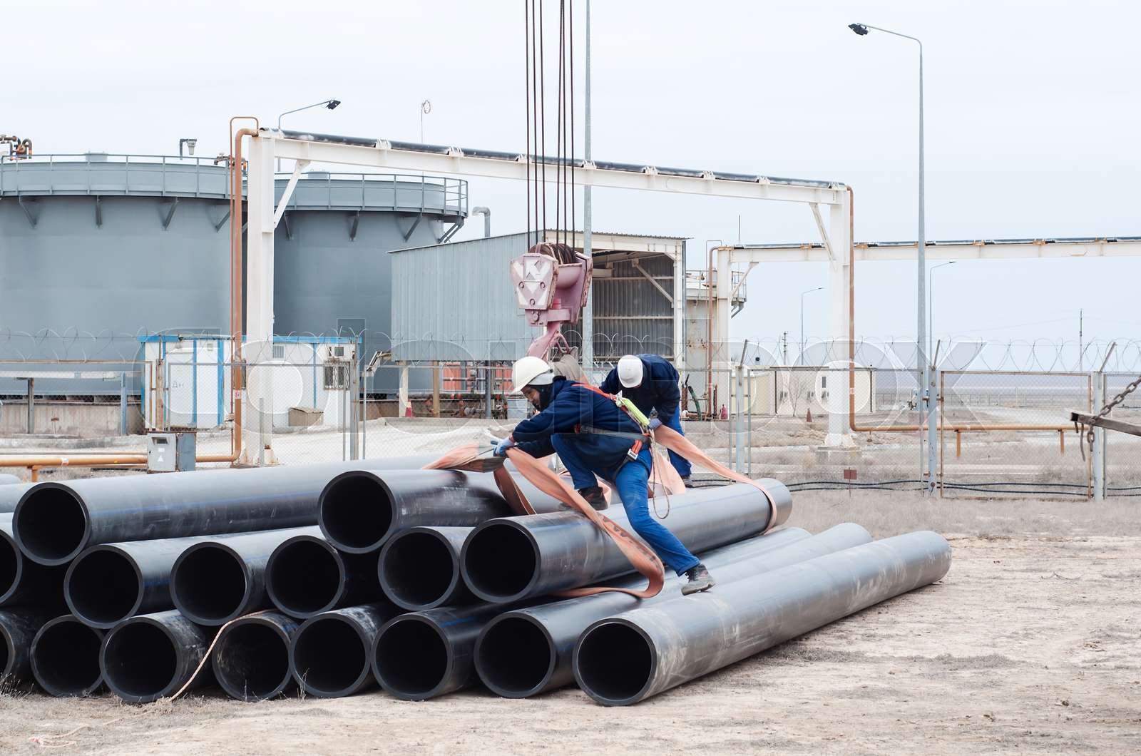 Work on unloading of pipes for construction. | Stock image | Colourbox