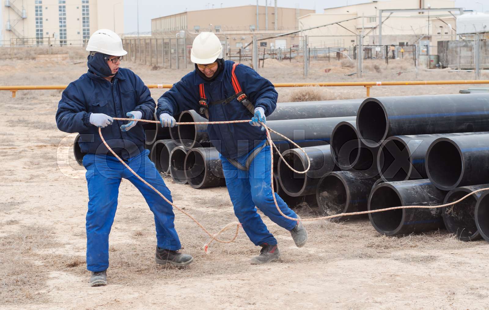 Work on unloading of pipes for construction. | Stock image | Colourbox